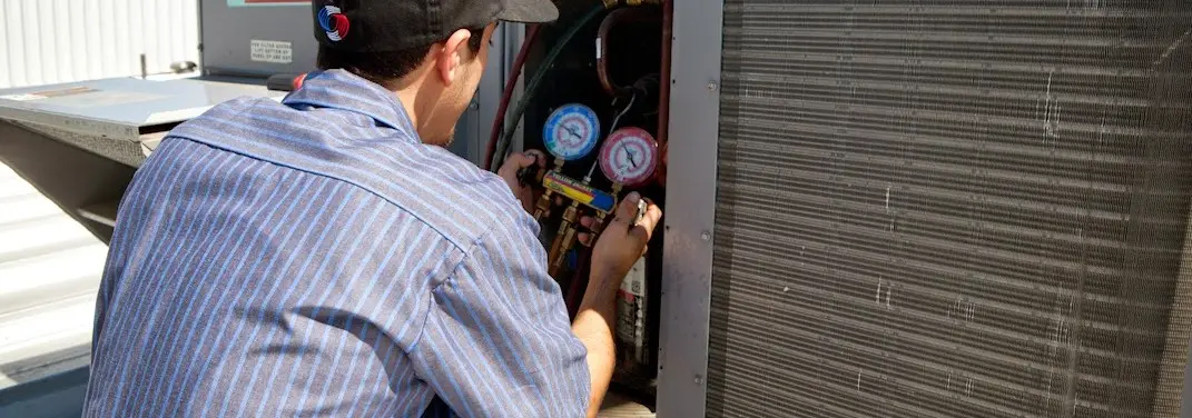 HVAC technician servicing a condenser unit in Pike Creek Valley